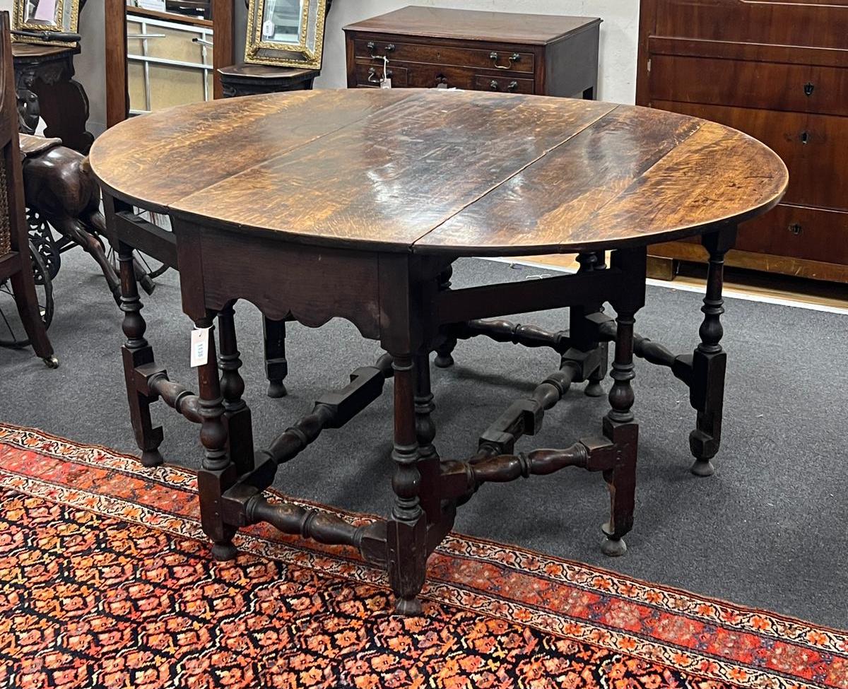 An 18th century oval oak gateleg dining table with turned under frame, width extended 146cm, depth 114cm, height 74cm